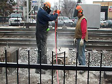 Workers drilling holes for Bustar expansive grout.